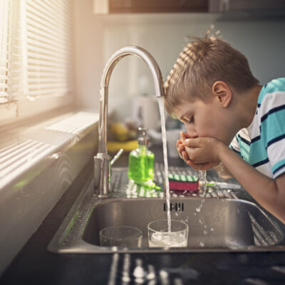 Little boy drinking tap water